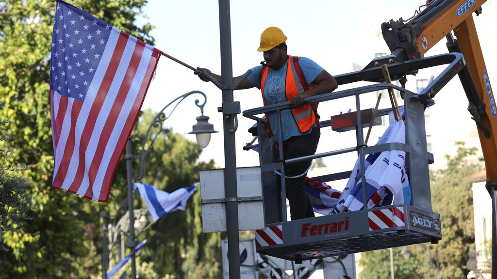 Jerusalem municipal workers hand American flags ahead of Biden's visit (Photo: EPA) תולים דגלי ארה"ב בירושלים לקראת ביקור ביידן