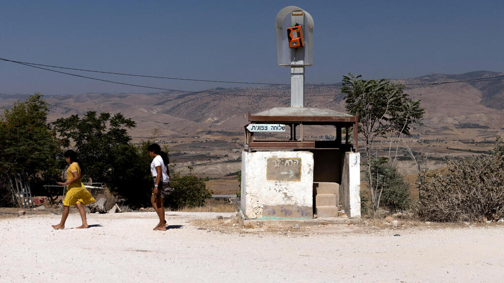 Israeli girls walk by a deserted guarding post at the Israeli settlement of Tomer in Jordan Valley 