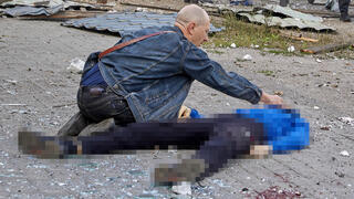 אב מלטף את גופת בנו שנהרג ב הפגזה שפגעה בתחנת אוטובוס חרקוב אוקראינה מלחמה רוסיה