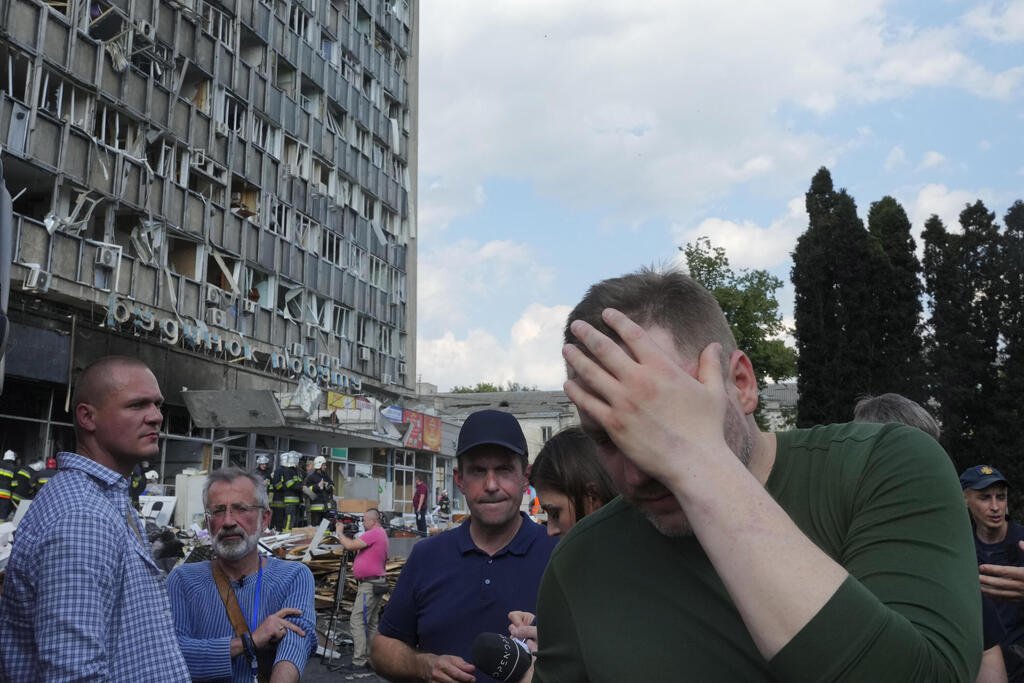 Ukrainian Interior Minister Denys Monastyrsky, right, reacts at a scene of damaged by shelling building in Vinnytsia, Ukraine