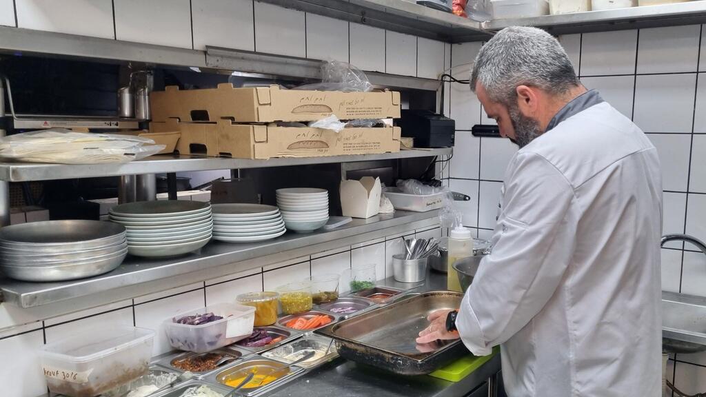 Chef Or Shapira prepares hybrid hamburgers at the Margoza Bar in Jaffa 