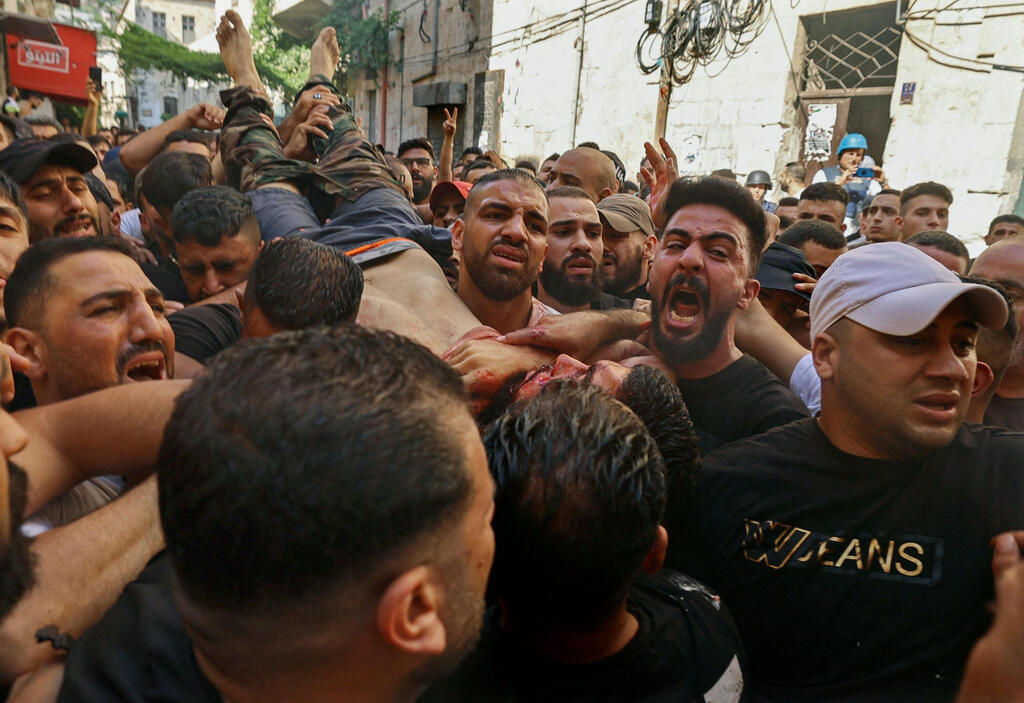 Palestinians carry the body of slain Ibrahim al-Nablussi in Nablus on Tuesday 
