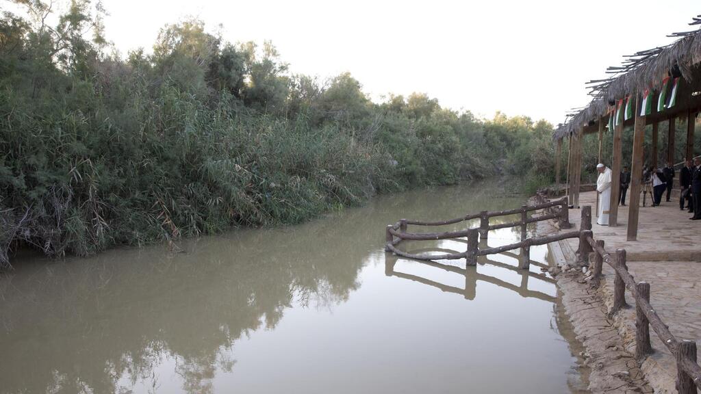 Pope Francis prays in front of the Jordan River at the Bethany beyond the Jordan baptismal site 