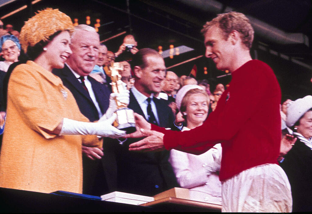 המלכה אליזבת השנייה מעניקה לבובי מור את גביע העולם 