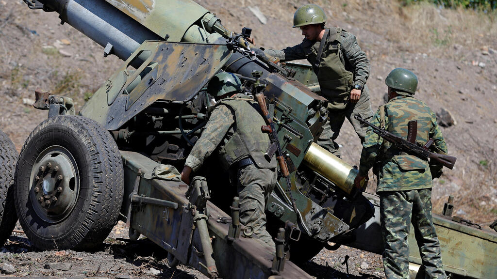 לוחם של כוחות מורדים פרו-רוסים ב דונייצק מזרח אוקראינה מבצע ירי ארטילריה ב תותח הוביצר לעבר העיירה אבדיבקה חבל דונבאס מלחמה רוסיה 7 בספטמבר