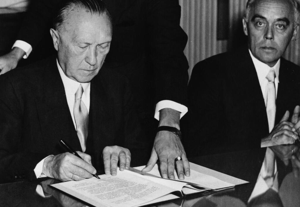 West German Chancellor Konrad Adenauer signs agreements providing compensation for Jews who suffered under Nazi Germany in a ceremony in Luxembourg on September 1952