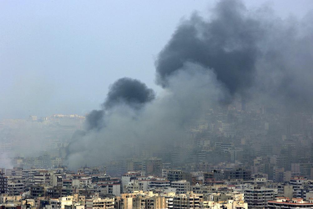 Black smoke rises from the demolished headquarters of Hezbollah in the suburbs of Beirut, Lebanon, following Israeli air strikes, July 16, 2006 