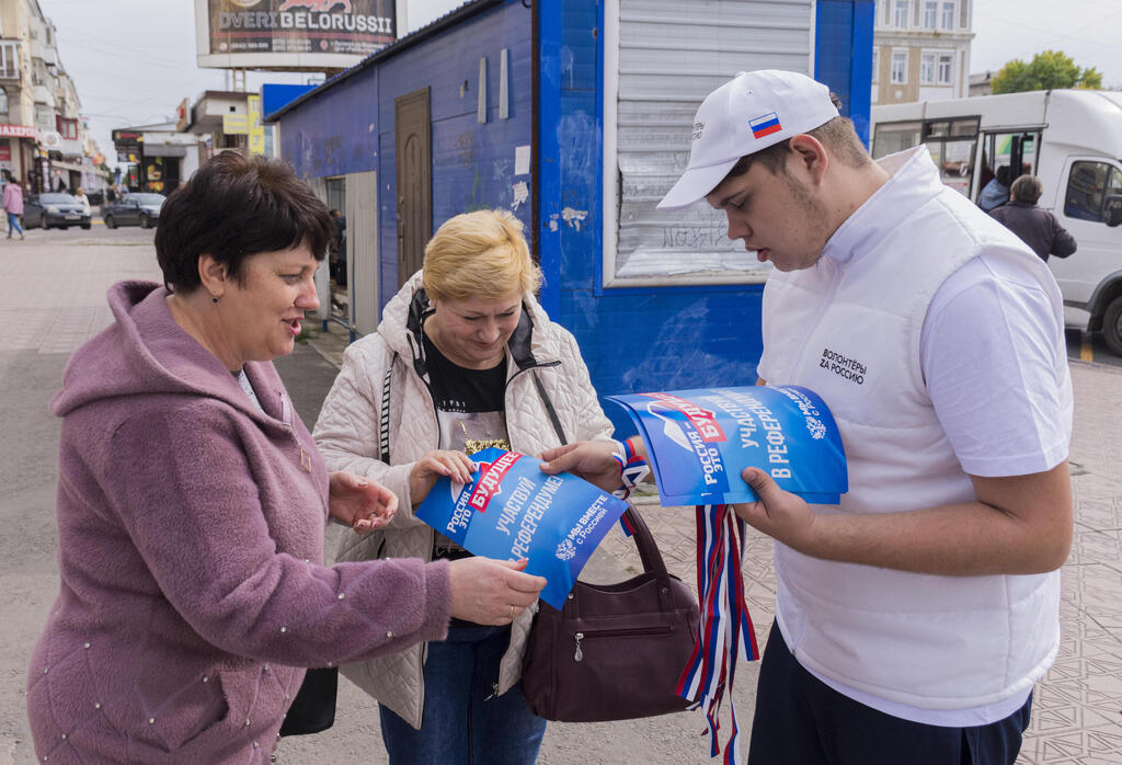 לוהנסק אוקראינה מתנדבים מחלקים פליירים קוראים להצטרף לרוסיה לקראת משאל עם
