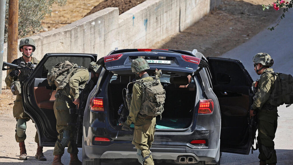 IDF soldiers search a Palestinian car in the Nablus area (Photo: AFP) כוחות צה"ל בכפר סאלם