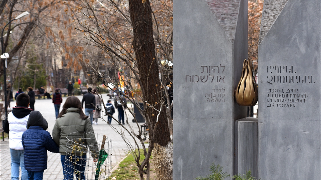 People walk past the Holocaust memorial in Yerevan, which is inscribed in Hebrew and Armenian: “To be or to forget: Remember the victims of the Shoah.” 
