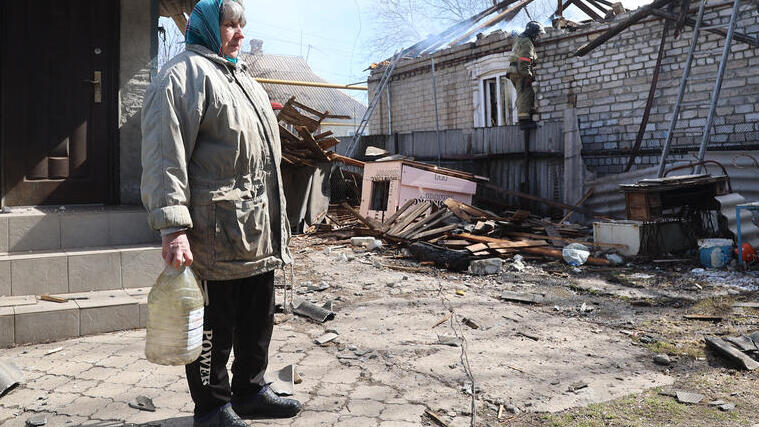 Elderly woman stand amid destruction in Eastern Ukraine 
