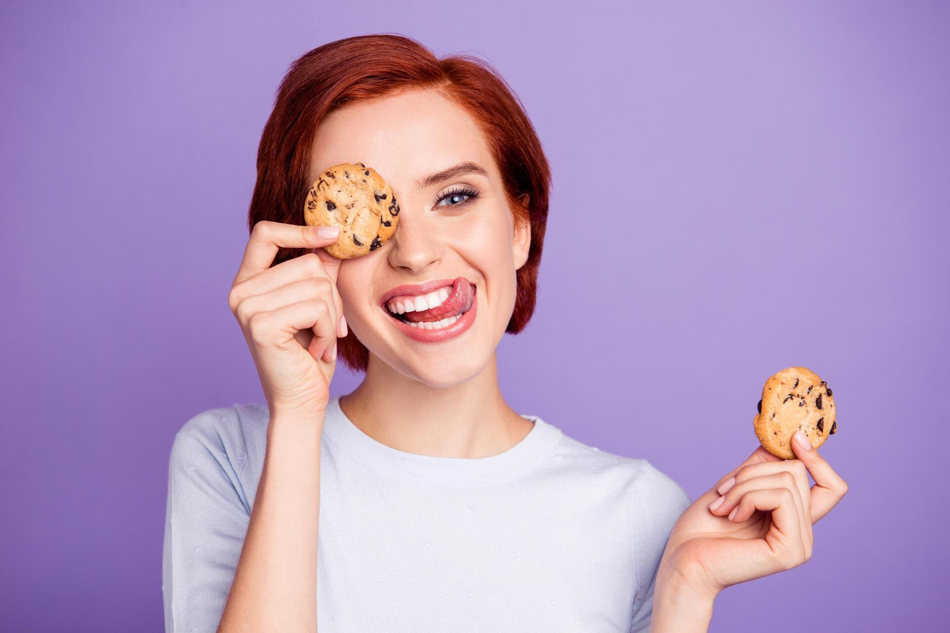 אישה מחייכת ומחזיקה עוגיות