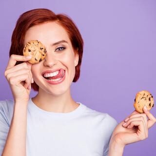 אישה מחייכת ומחזיקה עוגיות