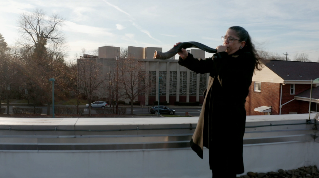 Audrey Glickman, a survivor of the 2018 Tree of Life synagogue shooting in Pittsburgh, blows the shofar outside the building in the new HBO documentary ‘A Tree of Life’ 