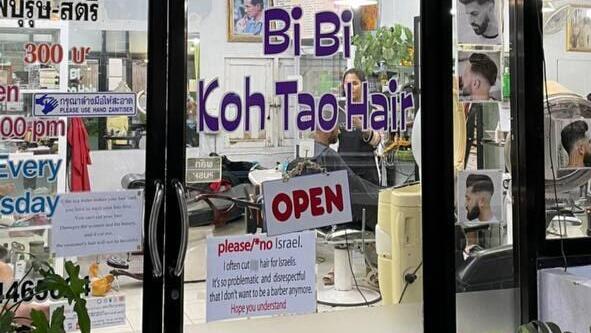 Barber shop's front door with the sign attached (Photo: Ziv Paz) השלט שמבקש מישראלים לא להיכנס למספרה