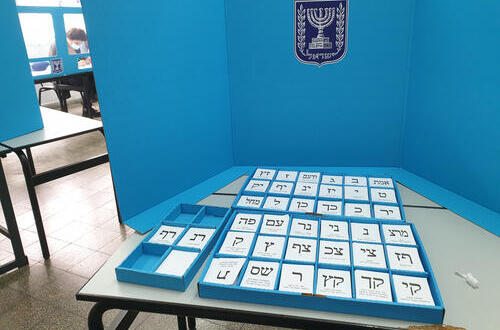 Коробка с избирательными бюллетенями и ширма. На заднем планы - члены избирательной комиссии 