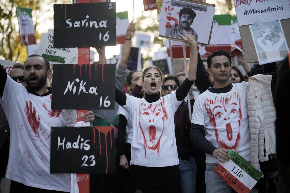 People attend a protest against the Iranian regime, in Berlin, Germany, Saturday, Oct. 22, 2022, following the death of Mahsa Amini in the custody of the Islamic republic's notorious "morality police" 