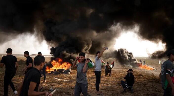 Palestinians burn tires during a protest against Israeli military 