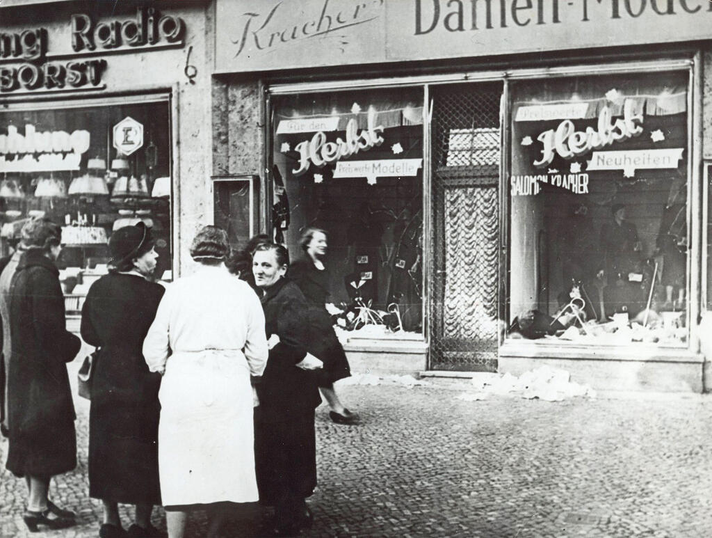 November 1938 file photo shows a group of people standing outside a Jewish-owned shop in an unnamed German town, after the Kristallnacht, when Nazi-incited mass riots left more than 91 jews dead, damaged more than 1,000 synagogues and left some 7,500 Jewish businesses ransacked and looted 