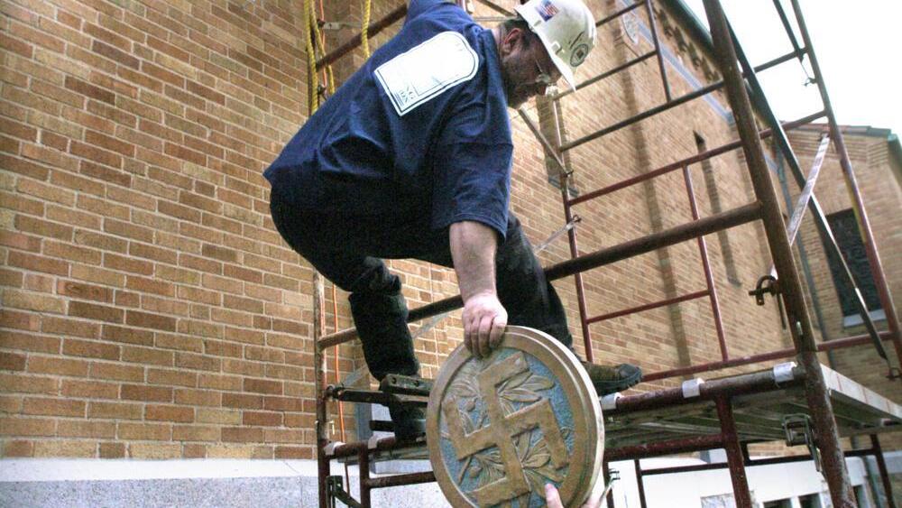  Brian Marquardt of Applegate Building Restoration lowers a Swastika symbol to the ground after it was removed from the north side of St. Mary's Cathedral in St. Cloud, Minn., Tuesday, May 2, 2006. The symbols were installed when the cathedral was constructed in the 1920s 