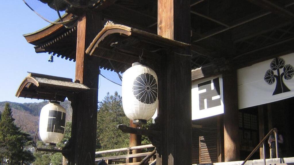 This photo provided by the Rev. TK Nakagaki in November 2022 shows the Zenko-jo Buddhist temple in Nagano, Japan, founded in 642 AD, Japan's first Buddhist temple. The swastika symbol is found in the temple's banners, paper lanterns, pillars, roof tiles and in the main shrine alongside the temple crest design of the hollyhock flower 