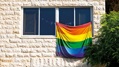 Радужный флаг на окне жилого дома. 