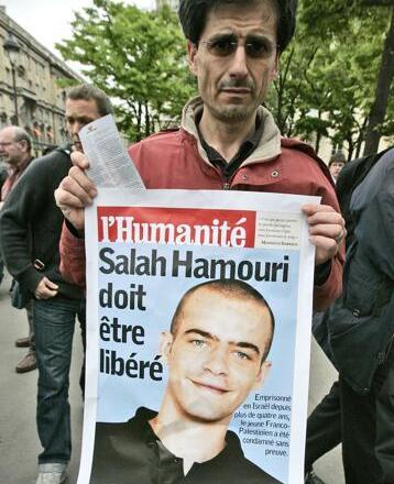 A member of a pro-Palestinian group holds a poster showing French-Palestinian Salah Hammouri, then detained in Israel after a sentencing by a military court, near the Foreign ministry in Paris to protest the visit of Israeli Foreign minister Avigdor Lieberman to his French counterpart, Tuesday May 5, 2009. The placard reads "Salah Hammouri must be freed" 