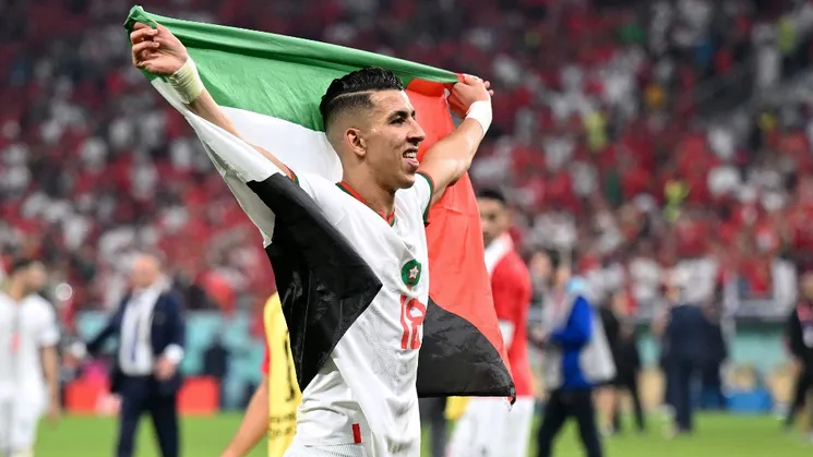 Morocco's defender Jawad El Yamiq waves the Palestinian flag after his team the Qatar 2022 World Cup football match between Canada and Morocco at the Al-Thumama Stadium in Doha, Qatar 