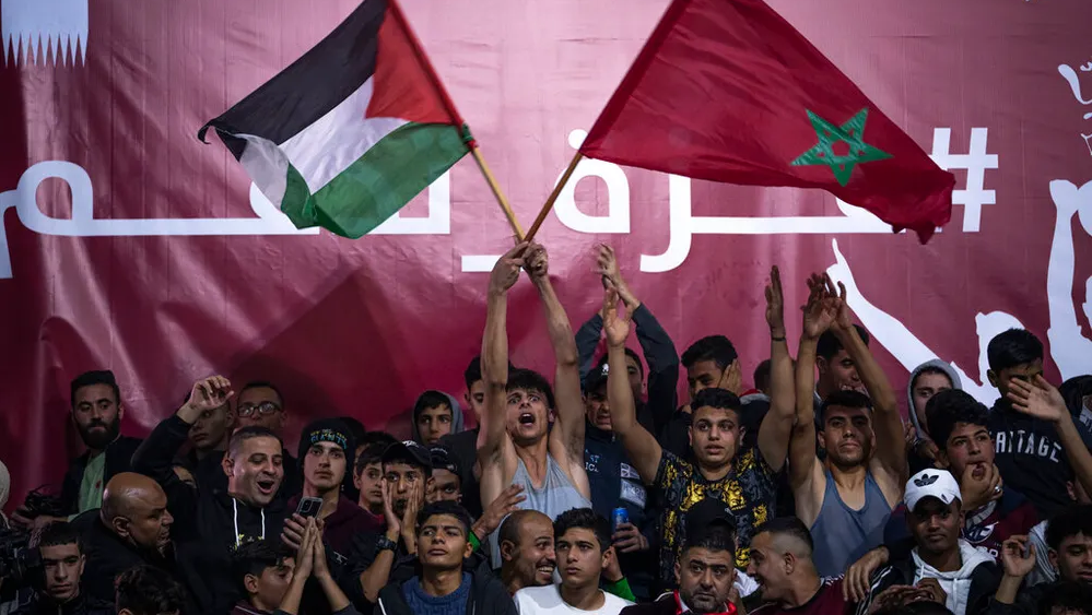 Palestinians wave Moroccan and their national flags as they watch a live broadcast of the World Cup quarterfinal soccer match between Morocco and Portugal played in Qatar, in Gaza City 