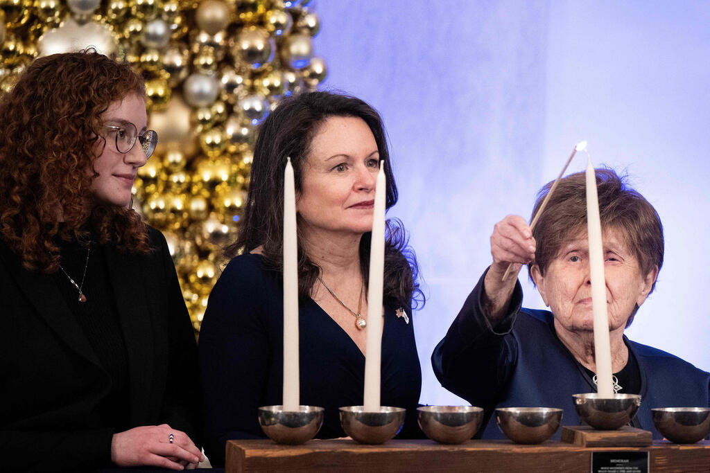 Holocaust Survivor Bronia Brandman lights a Menorah candle during a White House Hanukkah Holiday Reception 