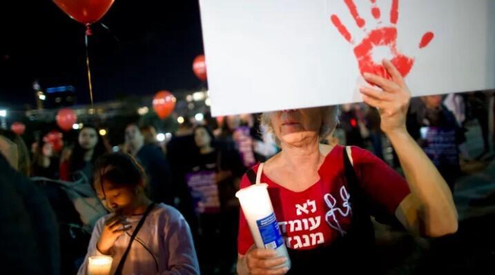 A woman holds a sign during a protest against violence against women 