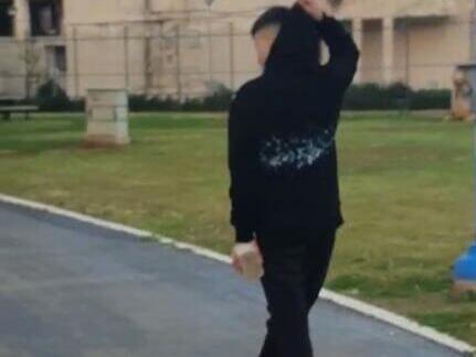 One of the teenagers who beat Abraham, holding a brick אחד התוקפים מחזיק בידו לבנה