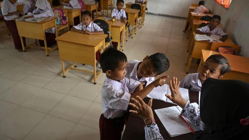A teacher speaks with pupils during class at a school in a remote village in Panca, Indonesia (Photo: CHAIDEER MAHYUDDIN / AFP) A teacher speaks with pupils during class at a school in a remote village in Panca, Indonesia