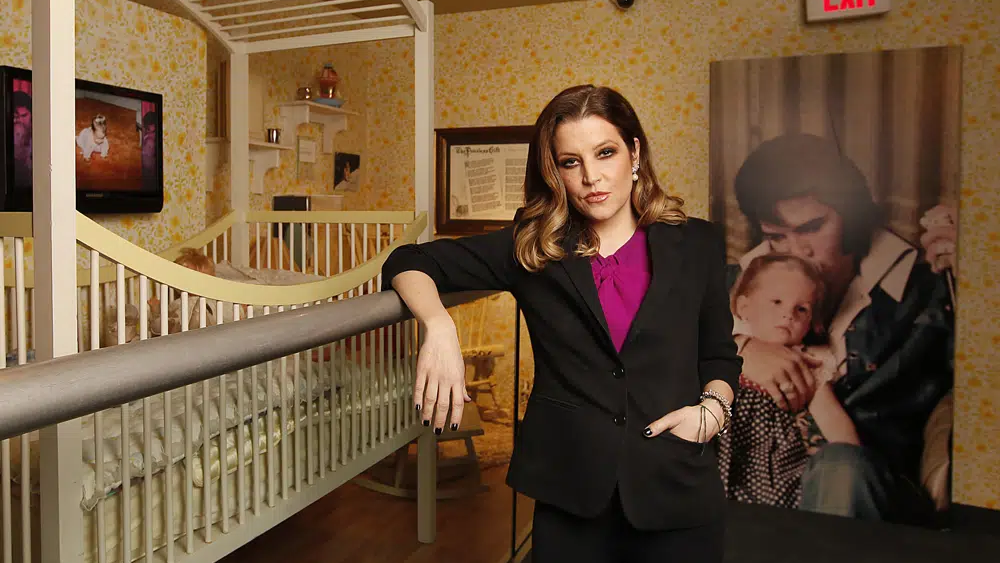 Lisa Marie Presley stands next to her childhood crib displayed with other mementos in the new exhibit "Elvis Through His Daughter's Eyes," at Graceland in Memphis, Tenn., Jan. 31, 2012 