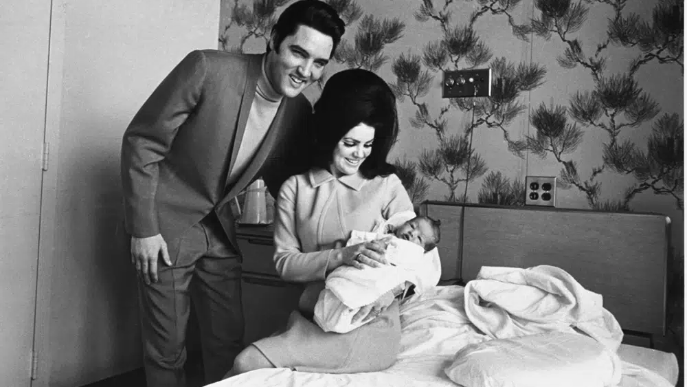 Lisa Marie Presley poses for her first picture in the lap of her mother, Priscilla, on Feb. 5, 1968, with her father, Elvis Presley 