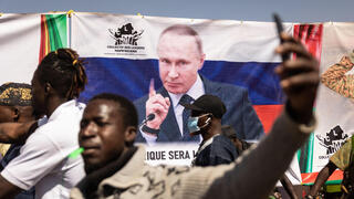 מפגינים ב בורקינה פאסו בעד הנשיא המקומי בדרישה שחיילי צרפת יעזבו ברקע כרזה של ולדימיר פוטין