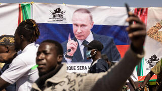 מפגינים ב בורקינה פאסו בעד הנשיא המקומי בדרישה שחיילי צרפת יעזבו ברקע כרזה של ולדימיר פוטין