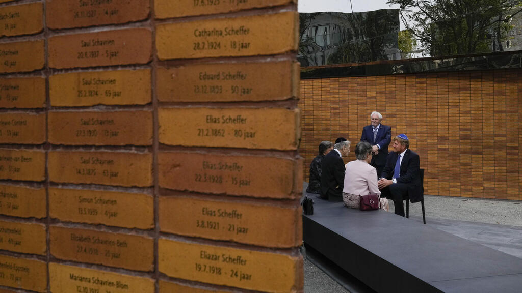 King Willem-Alexander, right, talks to survivors and relatives after officially unveiling a new monument in the heart of Amsterdam's historic Jewish Quarter on Sept. 19