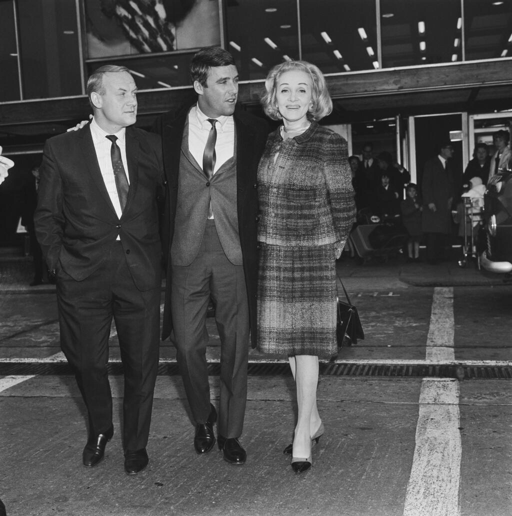 Bacharach (center) met by German-born actress and singer Marlene Dietrich at London Airport, for a visit to the UK, November 21, 1964 (Photo: Gettyimages) Bacharach (center) met by German-born actress and singer Marlene Dietrich at London Airport, for a visit to the UK, November 21, 1964
