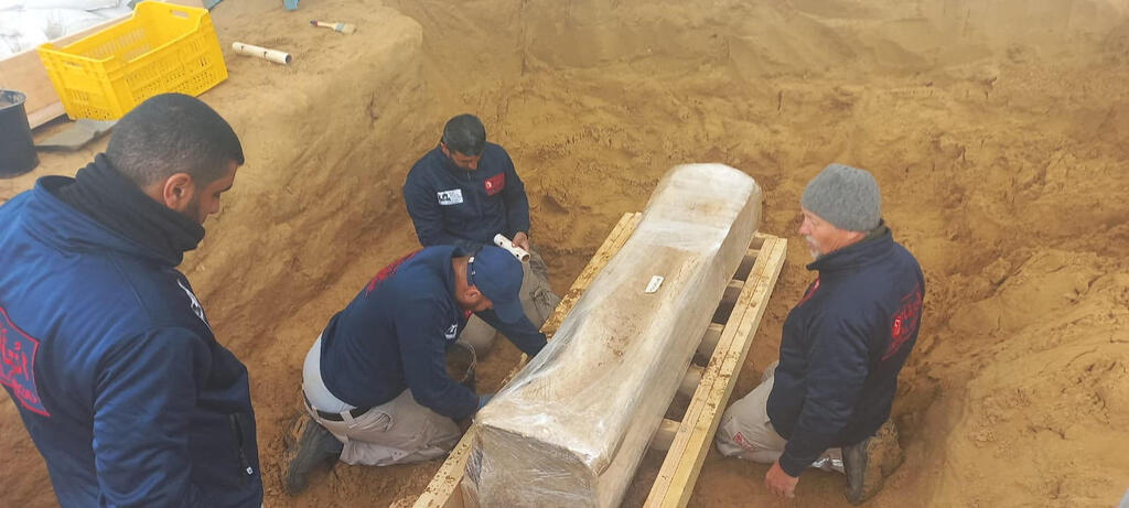 A team of archeological experts and workers preserve a newly-discovered Roman coffin in a wooden box at the site of a 2000-year-old Roman cemetery in northern Gaza Strip, February 14, 2023 