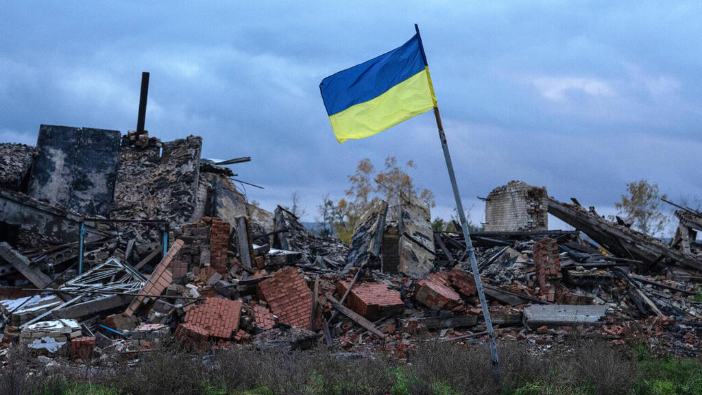 A Ukrainian flag flies above the ruins of buildings destroyed during fighting between Ukrainian and Russian forces Kam'yanka, in the Kharkiv oblast of Ukraine, Oct. 24, 2022 