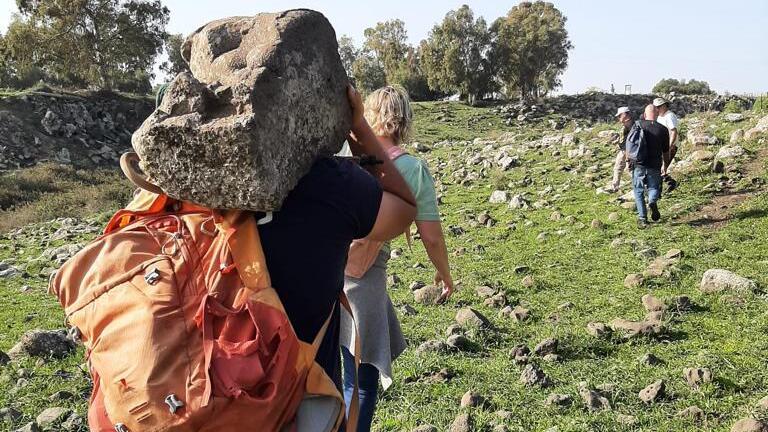 סטודנט לוקח את האבן, לאחר שדיווח על התגלית הועבר לרשות העתיקות