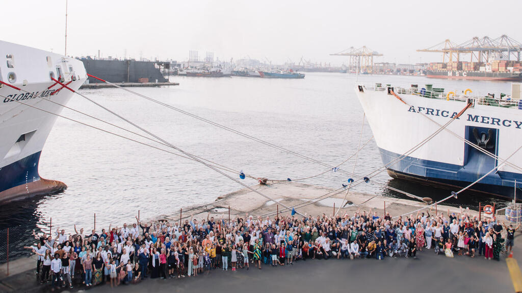 מאות מתנדבים מ-60 מדינות על רקע האוניה - אחי קושניר