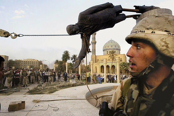 Iraqi civilians and U.S. soldiers pull down a statue of Saddam Hussein in downtown Baghdad, in this April 9, 2003