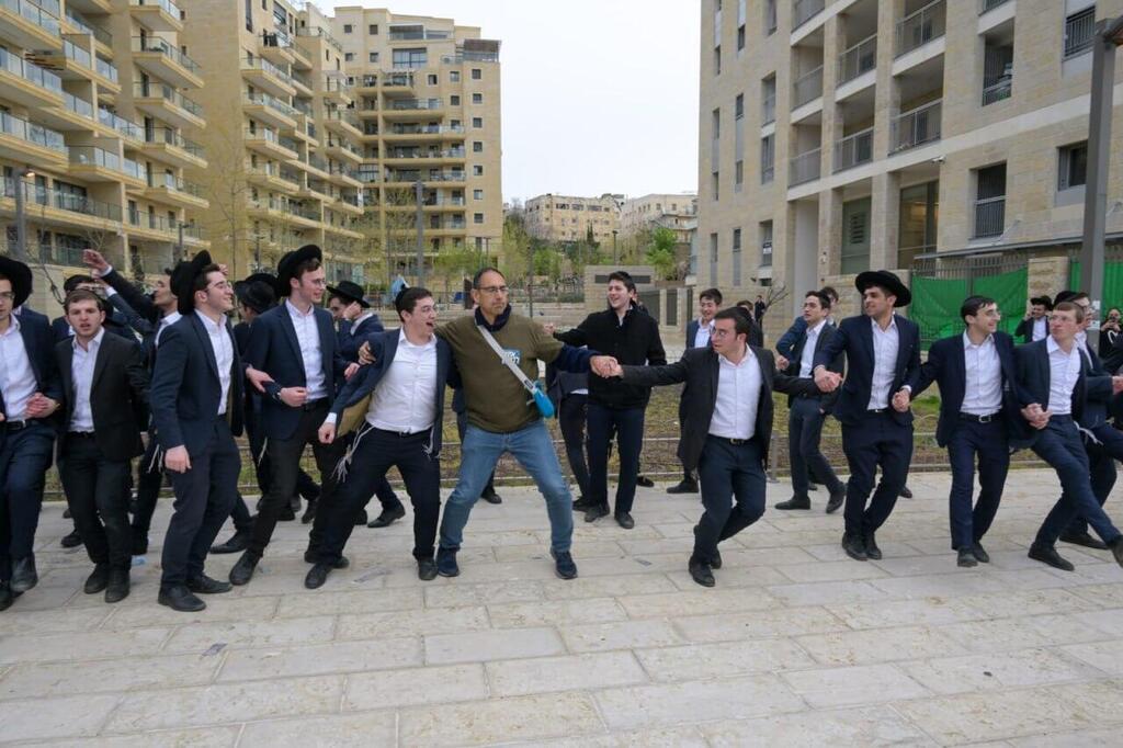Protest organizer Amit Farber dancing with Haredi youths in front of Arye Deri's Jerusalem home