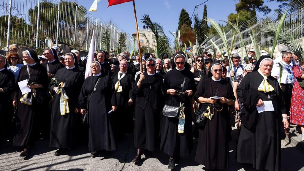 Nuns and other Christian worshippers attend a Palm Sunday procession 