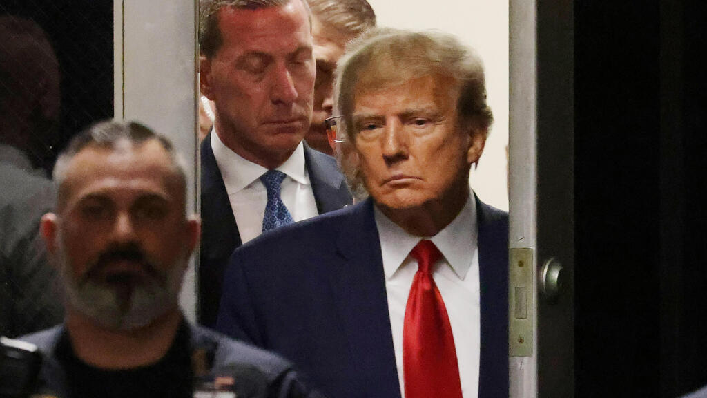 Трамп выходит от прокурора и идет к судье (Фото: EPA) נשיא ארה"ב לשעבר דונלד טראמפ פנים עגומות יוצא מ מתן טביעות אצבעות כתב אישום בית משפט