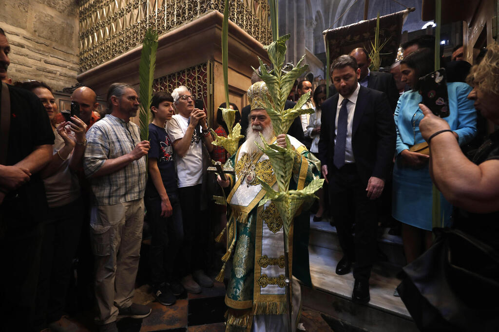 Greek Orthodox Patriarch of Jerusalem Theophilos III (C) holds palm branches as he takes part in the Orthodox procession during Palm Sunday in the Church of the Holy Sepulcher in Jerusalem, April 9, 2023 