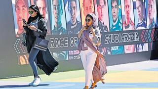 נשים סעודיות על רקע כרזה של מרוץ מכוניות