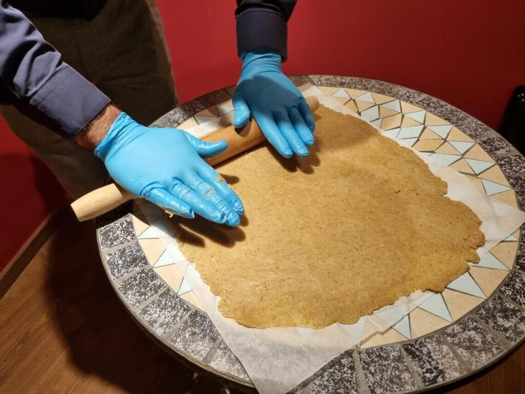 Avi Yefet, caretaker of the Karaite synagogue, rolls out dough to make 'massa' for Passover 
